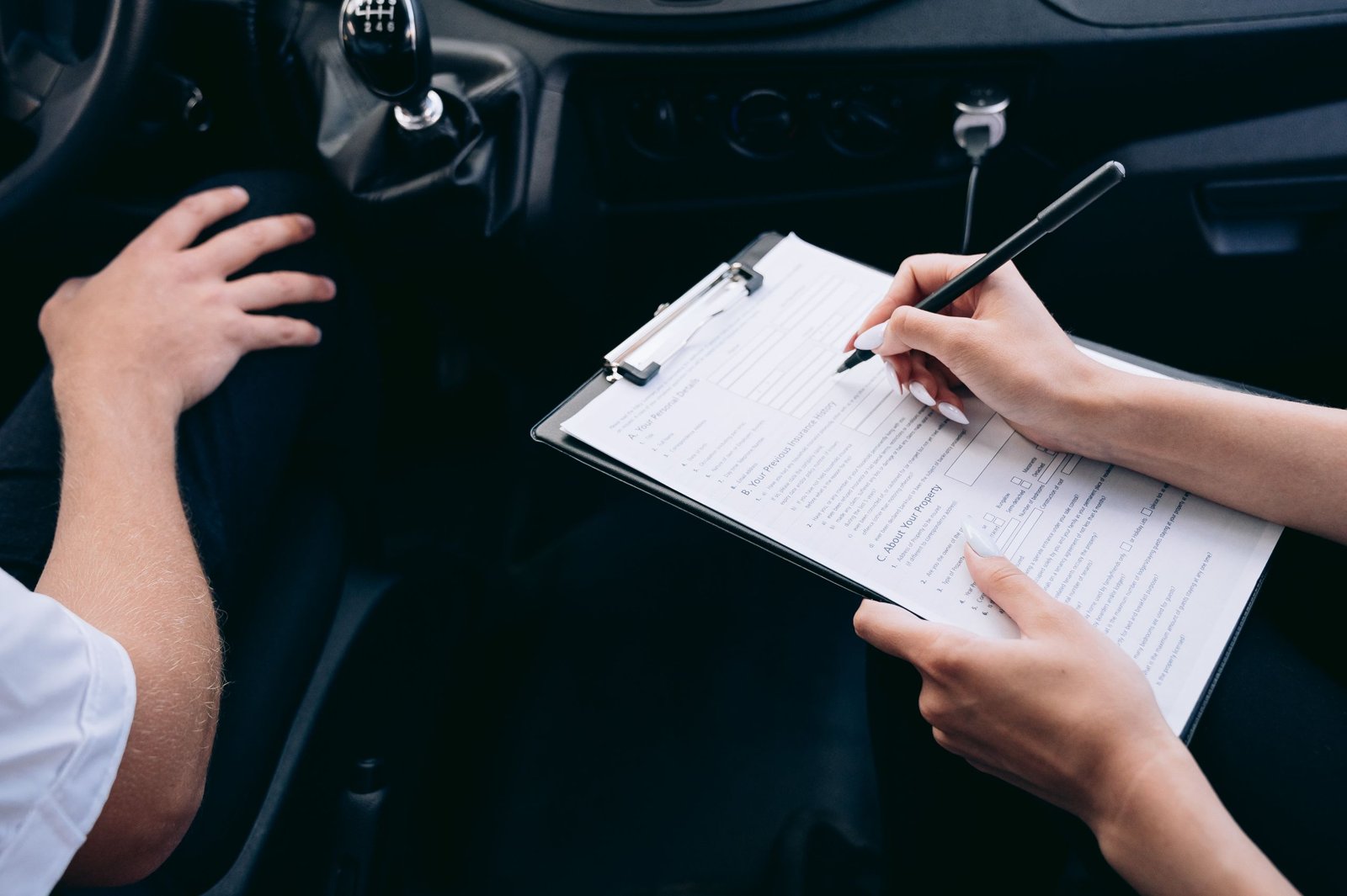 Assuré remplissant une déclaration circonstanciée sur papier libre après un accident, stylo et constat